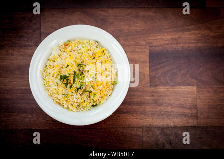 Schüssel mit Pilau-Reis auf Holzhintergrund Stockfoto