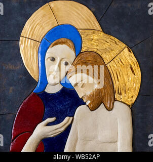 Ein Relief des trauernden Jungfrau Maria über ihren gekreuzigten Sohn Jesus Christus - eine Pieta von lubo Michalko. Stockfoto