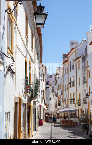 Weiß getünchte Häuser und Restaurants mit Terrassen in den Straßen der mittelalterlichen Stadt Évora in der Region Alentejo, Portugal. Stockfoto