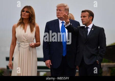 Der französische Präsident Emmanuel Längestrich trifft US-Präsident Donald Trump (Mitte), bei der offiziellen Begrüßung während der G7-Gipfel in Biarritz, Frankreich. Stockfoto