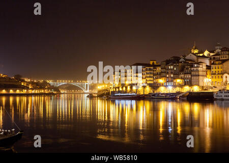 Der Fluss Douro (Rio Douro) und die malerische Stadt Porto mit dem Ponte da Arrábida, im Hintergrund in der Nacht, Portugal gesehen. Stockfoto