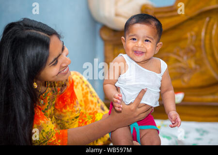 Eine asiatische Babys und ihre Mütter freches Lachen Bild zu Hause. Stockfoto