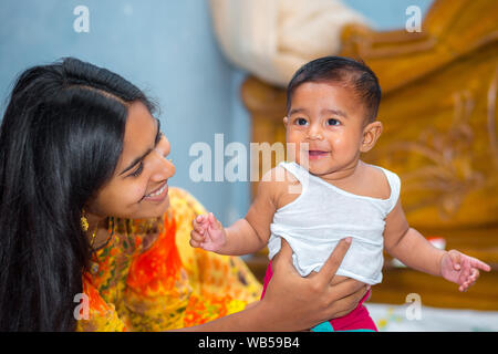 Eine asiatische Babys und ihre Mütter freches Lachen Bild zu Hause. Stockfoto