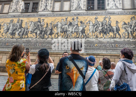 Dresden, Sachsen, Deutschland. Eine Gruppe von chinesischen Touristen bewundern die Wandgemälde der Fürstenzug (Fuerstenzug) aus Meissener Porzellan Stockfoto