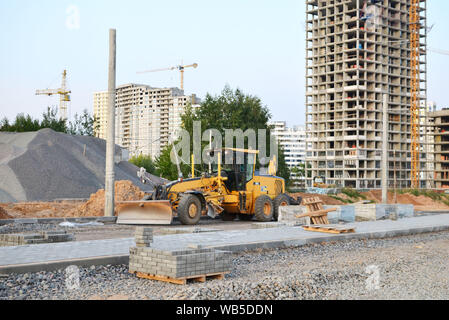 Сonstruction Maschine Motorgrader auf einer Baustelle auf dem Boden und Kies und Steine für den Bau einer neuen Asphalt. Straße konstruieren Stockfoto