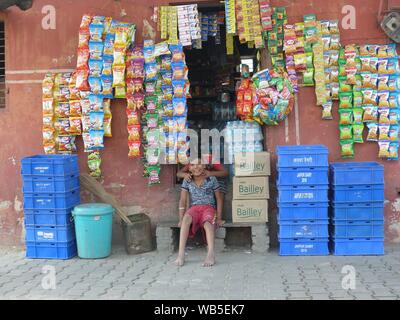 Zwei Jungen draußen sitzen ein Shop in Jaipur Straße Stockfoto
