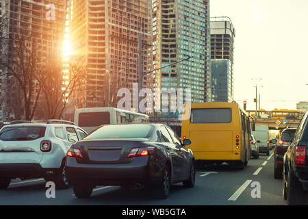 Autos onhighway in der Stadt Stau mit Sonnenuntergang Sonne Lichter durch hightower Baustelle für den Hintergrund. Metropole abendlichen Hauptverkehrszeit Szene Stockfoto