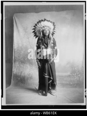 Eagle T-Shirt, Sioux Indianische, full-length Portrait, Blick leicht nach rechts, stehend vor Studio Hintergrund Stockfoto