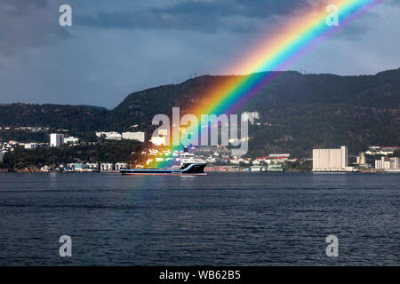 Ein Regenbogen glänzend über PSV Platform Supply Vessel Norden Pomor, Warten auf Liegeplatz außerhalb der Hafen von Bergen, Norwegen. Stockfoto