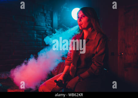 Frau raucht eine e-Zigarette liegen auf dem Bett im Zimmer. Raucher Konzept dampfen Stockfoto