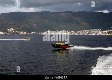 Zwei kleine High speed Sightseeing Boote der Skipper und Gemini Typ, mit hoher Geschwindigkeit in Byfjorden, Bergen, Norwegen. Sandviken im Hintergrund. Stockfoto