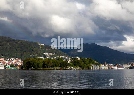 Blick auf Eingang in den Hafen von Bergen, Norwegen. Nordnes und der kommerziellen Hafen. Mount Floyen und Ulriken. Blick von der Insel Askoy Stockfoto