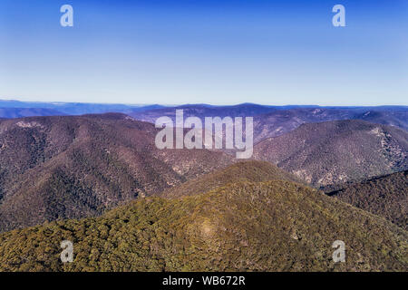 Berggipfel und reicht in der Blue Mountains Australien auf einem hellen, sonnigen Tag unter blauen Himmel über dicken Gummi-tree immergrüner Wälder in erhöhten Antenne Stockfoto