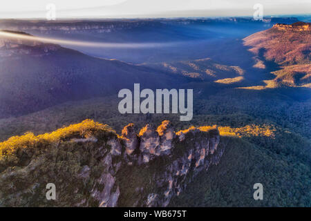 Sun Lichtstrahlen und Haze Kriechen zum Grand Canyon in den Blue Mountains in Australien über die Drei Schwestern Felsformation von oben Sonne gesehen Stockfoto