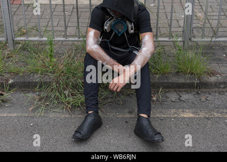 Eine Demonstrantin ruht, als Polizei und Demonstranten aufeinandertreffen während der Demonstration in Hongkong. Massendemonstrationen fährt für ein Wochenende in Hongkong, die im Juni 2019 über einen jetzt - verschobene Auslieferung Bill in China begann. Stockfoto