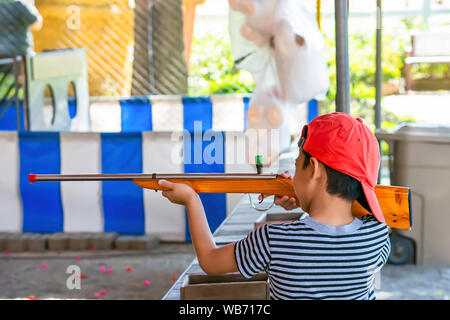 Der junge Holding ein Gewehr Spielzeug aus Holz. Stockfoto