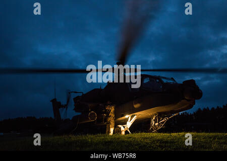 Der Soldat mit der 1. Staffel, 6 Kavallerie Regiments, 1 Combat Aviation Brigade, 1 Infanterie Division, tankt ein AH-64 Apache Kampfhubschrauber vor am frühen Morgen einen simulierten Angriff Mission während der kombinierten Lösung XII auf einer Strecke am Hohenfels Training Area, Germany, Aug 16., 2019. Kombinierte Lösung ist eine halbjährliche US-Army in Europa und der siebten Armee Befehl-led-Übung bestimmt zu bewerten und zertifizieren die Bereitschaft und die Interoperabilität der US-Streitkräfte in Europa zur Unterstützung der Atlantischen Lösen mobilisiert. (U.S. Armee Foto von Sgt. Jeremia Holz) Stockfoto