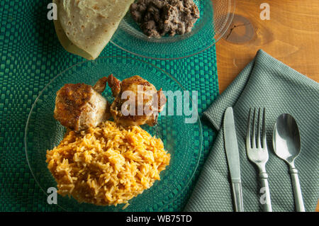 Gebratenes Huhn mit mexikanischer Reis, schwarzen Bohnen und Mehl Tortillas, als Teil der mexikanischen traditionelles Gericht. Stockfoto