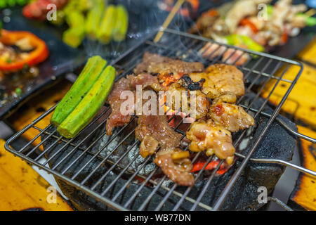Nahaufnahme von gegrilltem Fleisch und Gemüse auf Holzkohle Herd Stockfoto