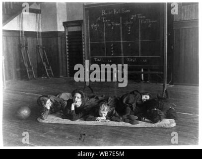 Fünf Mädchen liegen auf Matten in der Turnhalle vor Basketball scoreboard, Western High School, Washington, D.C. Abstract / Medium: 1 Foto: cyanotypie. Stockfoto
