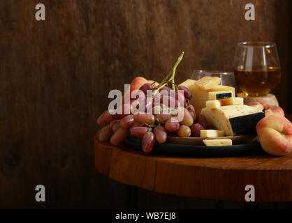 Käse, Trauben und Wein auf einem Holztisch, rustikalen Stil Stockfoto