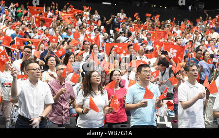 (190825) - Peking, Aug 25, 2019 (Xinhua) -- Menschen wave Flags während einer Veranstaltung von Hong Kong chinesische Unternehmen Verband organisierten Familien in ihrer Anrufe für Ordnung und Harmonie in der Ocean Park, South China Hong Kong, Aug 24, 2019 zu vereinen. (Xinhua / Lu Hanxin) Stockfoto