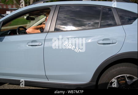 Storrs, CT USA. Aug 2019. Student der Fahrt einen Mietwagen Zipcar zu klassifizieren. Stockfoto