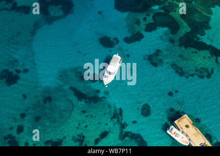 Ansicht von oben, atemberaubenden Blick auf einer Luxusyacht schwimmend auf einem smaragdgrünen Bucht von Wasser in Sardinien. Maddalena Archipelago National Park Stockfoto