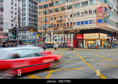 Rotes Auto bewegen auf gelben Kasten Kreuzung an der Nathan Road. Kowloon, Hong Kong, China. Stockfoto