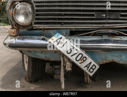 Altes Auto in Kieve, mit gebrochenen vorderen Nummernschild. Stockfoto