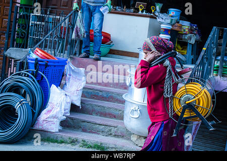 Shimla, Himachal Pradesh, Indien - 20. Juli 2019: Indische Frauen gehen auf die Straße. schweres Heben elektrische Kabel rollen auf den Kopf. Stockfoto