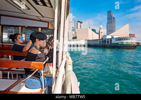 Touristen fotografieren von Star Fähre in den Victoria Harbour. Hongkong, China. Stockfoto