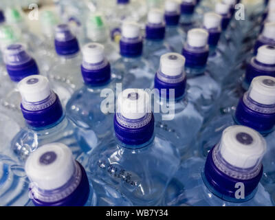 Reihen mit Wasser gefüllte Plastikflaschen mit Schraubverschluss Stockfoto