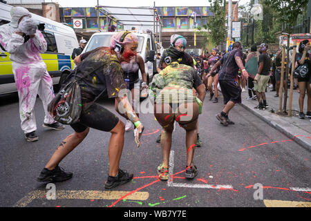 London, Großbritannien. 25. August 2019. Jouvert Parade startet der Notting Hill Carnival 2019 Festlichkeiten mit dem traditionellen Farbe, Öl und farbigen Pulver zu den Klängen der Afrikanischen Trommeln und Rhythmus bands geworfen wird. Credit: Guy Corbishley/Alamy leben Nachrichten Stockfoto