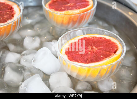 Rosa grapefruit Hälften in Glasschalen auf Eis Stockfoto