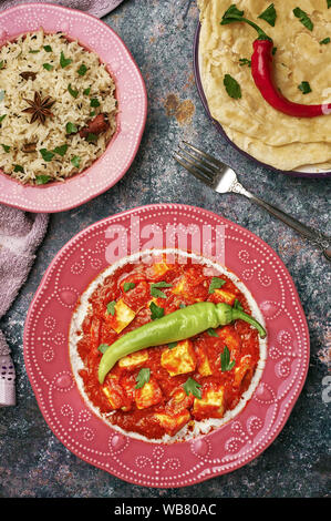 Paneer Makhani, Jeera Reis und paratha in rosa Platte auf dunklem Hintergrund. Paneer Makhani ist eine indische Küche curry mit paneer Käse, Tomaten und sp Stockfoto