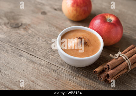 Frische hausgemachte Apfelmus (Apfelmus, Mousse, Sauce) mit Zimt und Apfel auf Holztisch, kopieren Raum Stockfoto