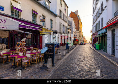 Paris, Frankreich, 7. Juli 2018: Straße bei Tabellen mit Cafe im Viertel Montmartre in Paris, Frankreich. Gemütliche Stadtbild von Paris. Architektur und Sehenswürdigkeiten o Stockfoto