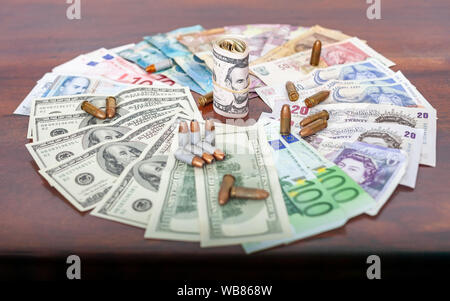 Schmutziges Geld zusammen mit Kugeln kriminelle Aktivitäten, Pfund, Dollar, Euro, Pula, Rand Stockfoto