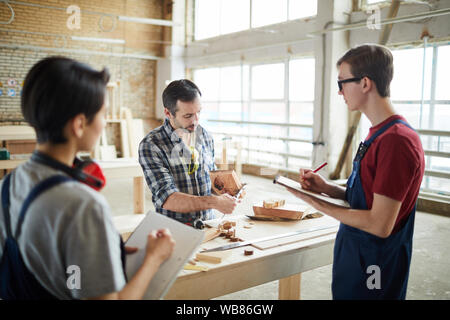 Taille bis Portrait von Reifen Tischler Lehre junge Auszubildende in der Werkstatt Stockfoto