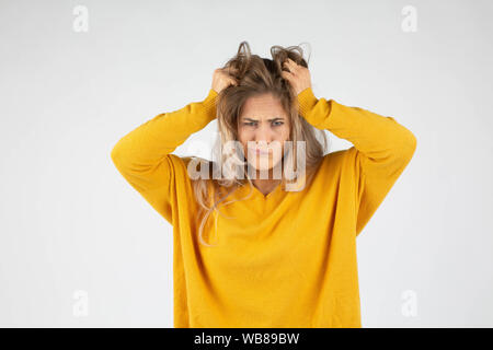 Blonde wütende Frau zerreißt ihre Haare, weil Wut und Stress Stockfoto