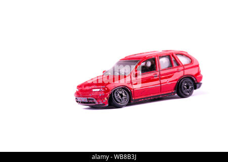 Zertrümmert und durch einen Unfall oder eine Störung kaputt Kinder Spielzeugauto auf weißem Hintergrund gebrochen Rad auf Kind rote Spielzeugauto close up Konzept o isoliert Stockfoto