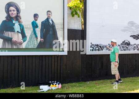 Bournemouth, Dorset UK. 25. August 2019. Der britische Künstler David Downes hat durch ITV beauftragt, ein großes Wandbild ihren neuen Drama Sanditon, auf der Grundlage des unvollendeten Roman von Jane Austen zu starten zu erstellen. Die wandgemälde von der fiktiven Stadt Sanditon wird 12 Meter breit sein und wird über 5 Tage ab heute vor der ersten Episode von sanditon auf TV heute Abend gemalt; das Wandbild wird dann auf dem Display für 3 Wochen. Credit: Carolyn Jenkins/Alamy leben Nachrichten Stockfoto