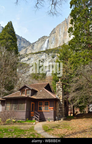 Yosemite National Park, USA - April 1, 2019: Holz- Haus in Yosemite National Park mit dem Fall im Hintergrund Stockfoto