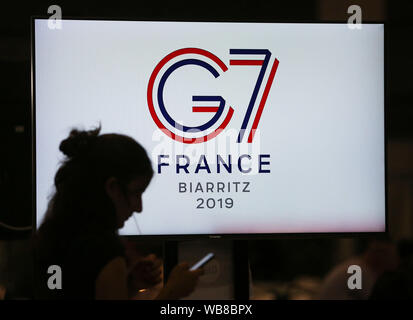 Biarritz, Frankreich. 25 Aug, 2019. Ein Journalist ist auf einem TV-Bildschirm auf dem G7-Gipfel in Biarritz, Frankreich, August 25, 2019. Die Staats- und Regierungschefs von sieben am stärksten industrialisierten Länder der Welt gestartet 45. Gipfel der geteilten Gruppe, durch einen Stapel schwierige Probleme mit den Spannungen hoch auf der Tagesordnung, am Samstag abend im französischen Badeort Biarritz getrübt. Credit: Gao Jing/Xinhua/Alamy leben Nachrichten Stockfoto