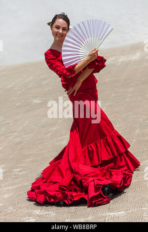 Spanisch weiblich Frau Flamenco Tänzerin Durchführung außerhalb trägt ein rotes Kleid mit einem weissen Fan posiert Stockfoto