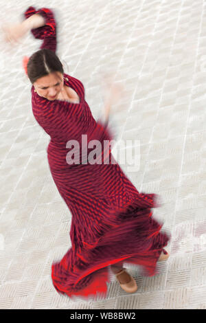 Motion verschwommenes Foto von Spanischen weiblich Frau Flamenco Tänzerin Durchführung außerhalb in einem roten Kleid Stockfoto