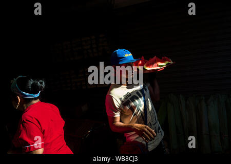 Ein Afro-Straße Verkäufer trägt Scheiben Wassermelone auf dem Markt der Bazurto in Cartagena, Kolumbien. Stockfoto