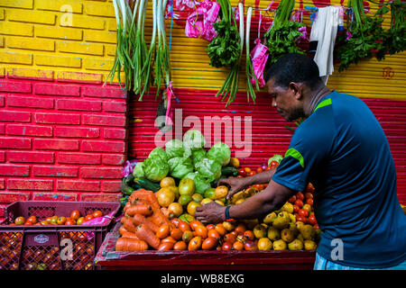 Ein Afro markt anbieter verkauft frisches Obst und Gemüse auf dem Markt der Bazurto in Cartagena, Kolumbien. Stockfoto