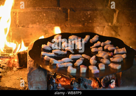 Salo ist in einer Pfanne in einem Ofen auf ein Feuer gebraten. Die Röstung Schmalz im Grill. Barbecue im Sommer im Freien. Schweinefett auf dem Scheiterhaufen. Kochen Street Food. r Stockfoto